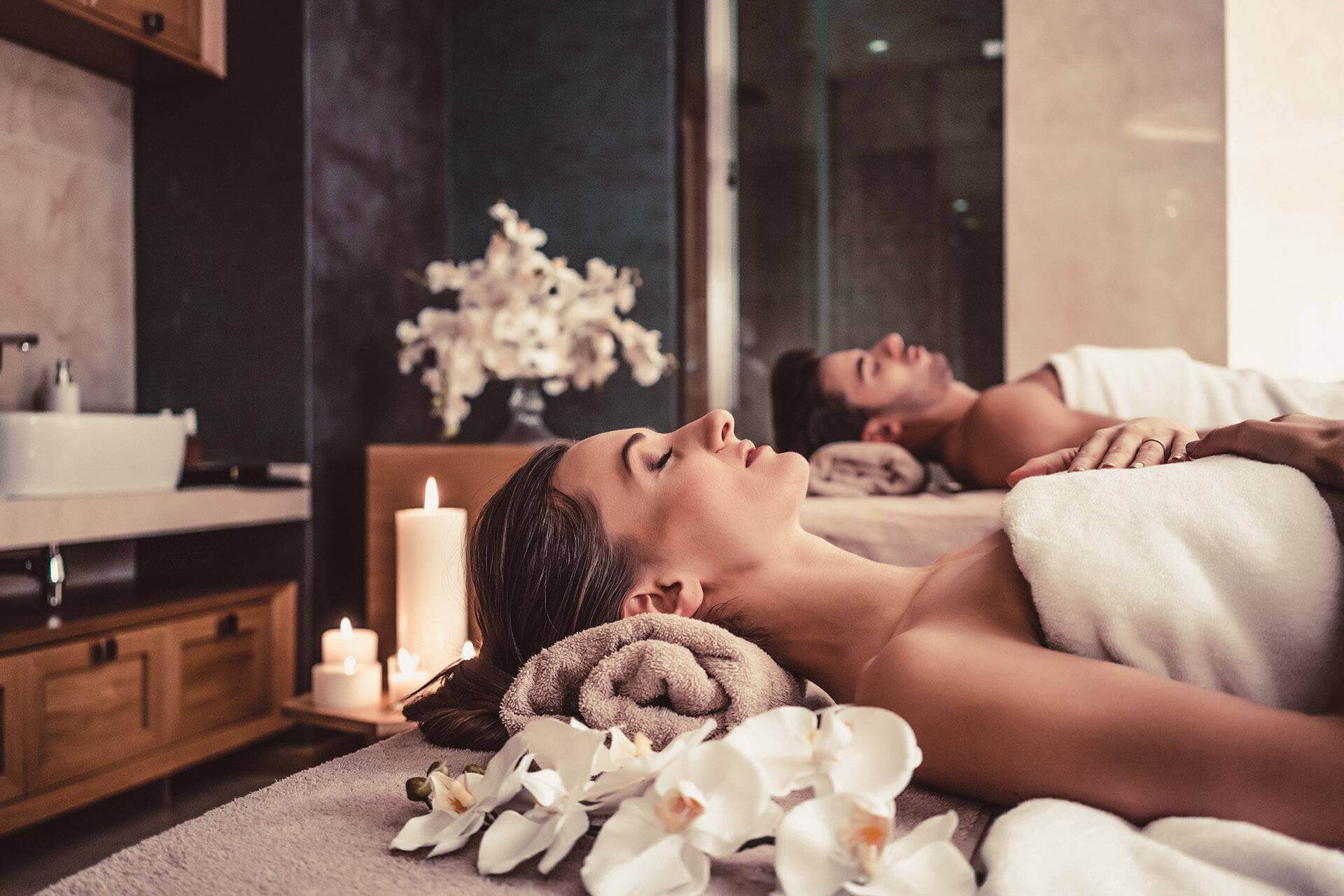 Man and woman lying down on massage beds at Asian wellness center