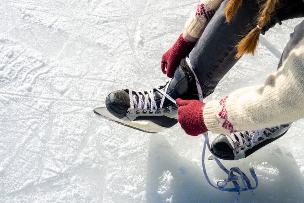 Woman tying ice skate shoelaces close up